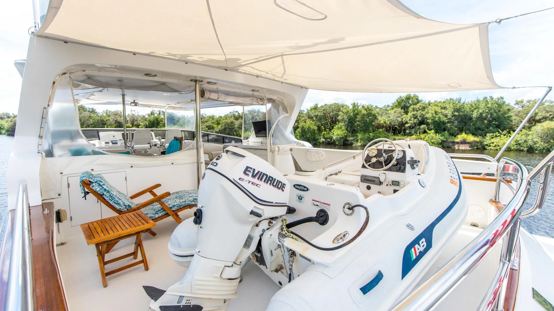 a white boat with a blue and white sail on a wooden dock aboard DREAMCHASER Yacht for Sale