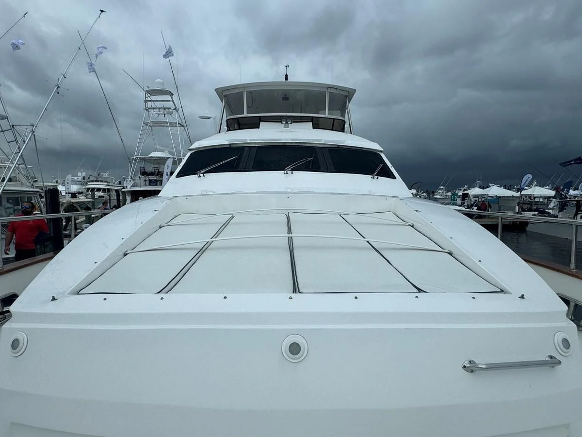 a white yacht in a harbor with Ice hockey rink in the background aboard DREAMCHASER Yacht for Sale