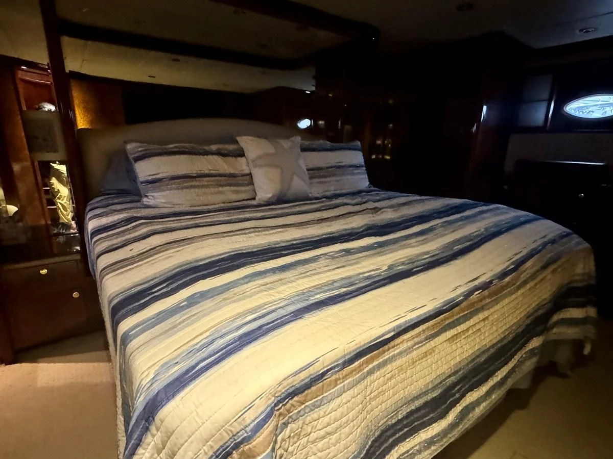 a bed with a blue comforter aboard DREAMCHASER Yacht for Sale