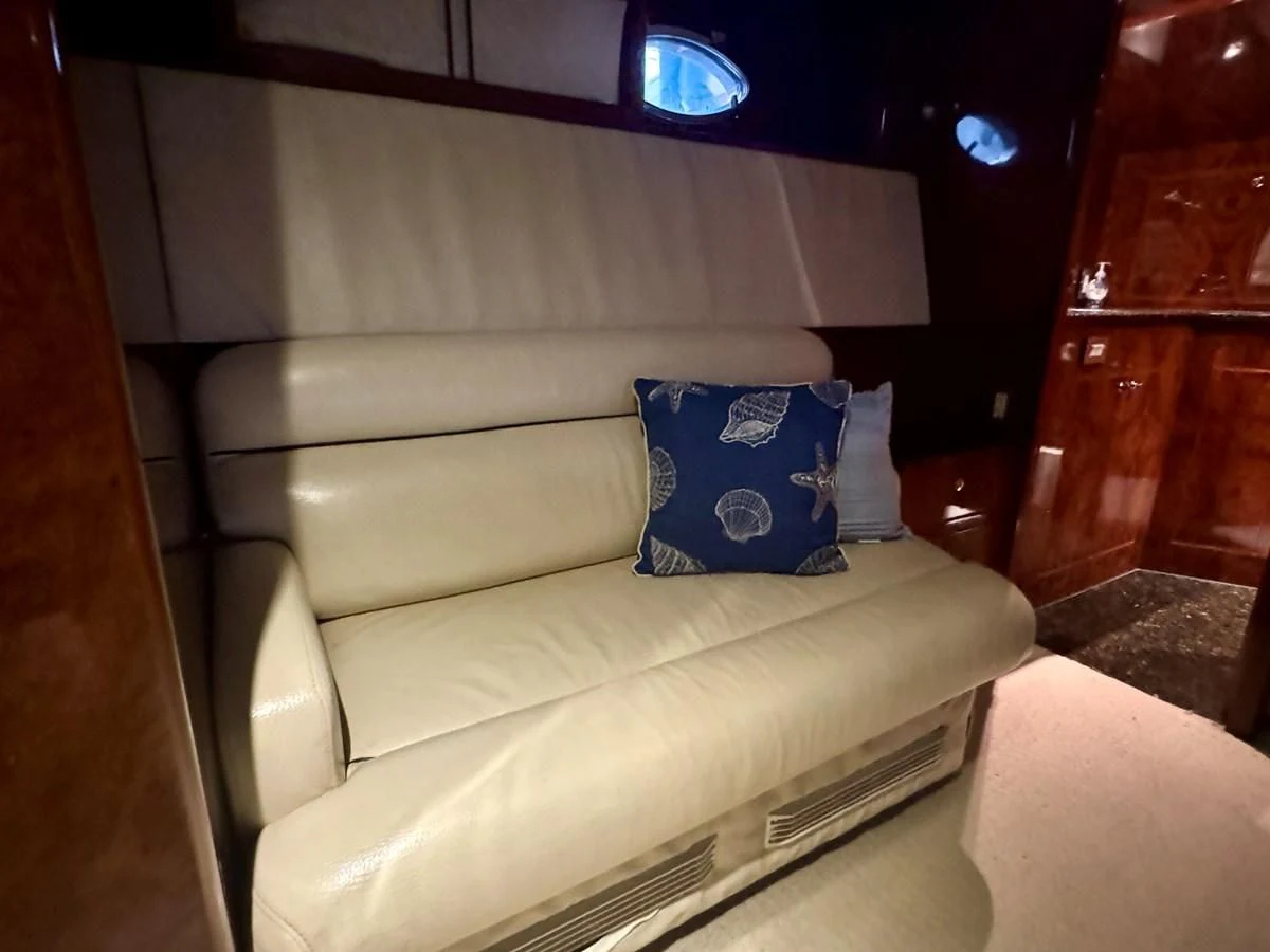 a couch with a blue pillow on it aboard DREAMCHASER Yacht for Sale