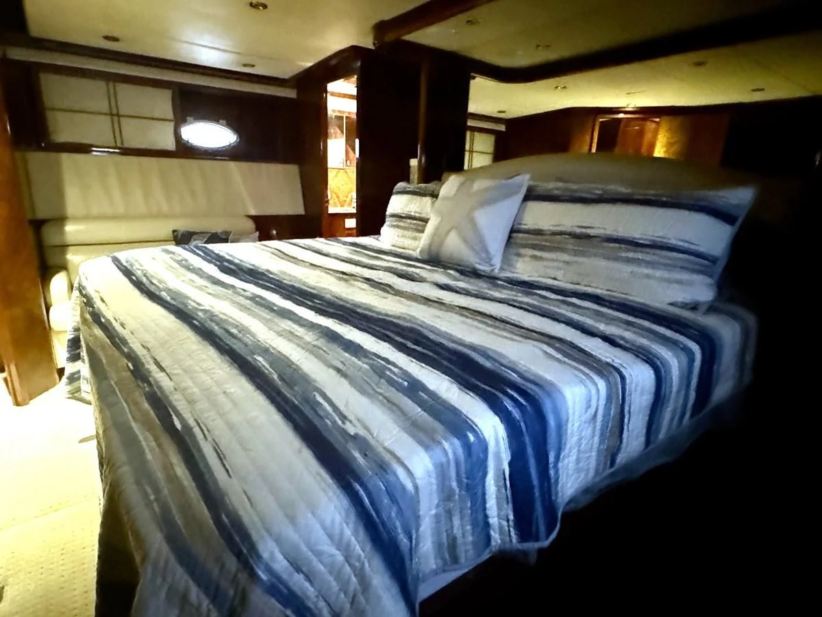 a bed with a blue comforter aboard DREAMCHASER Yacht for Sale