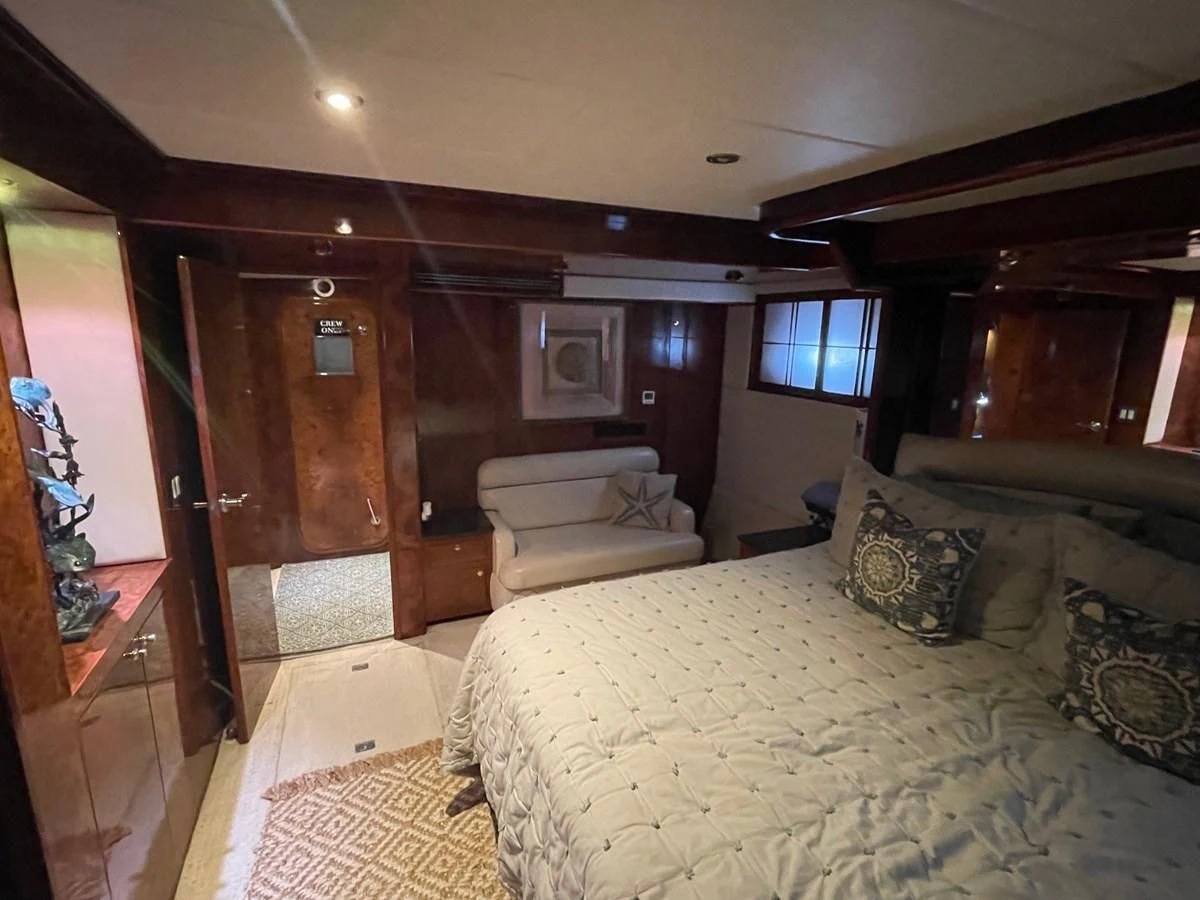 a bedroom with a bed and a couch aboard DREAMCHASER Yacht for Sale