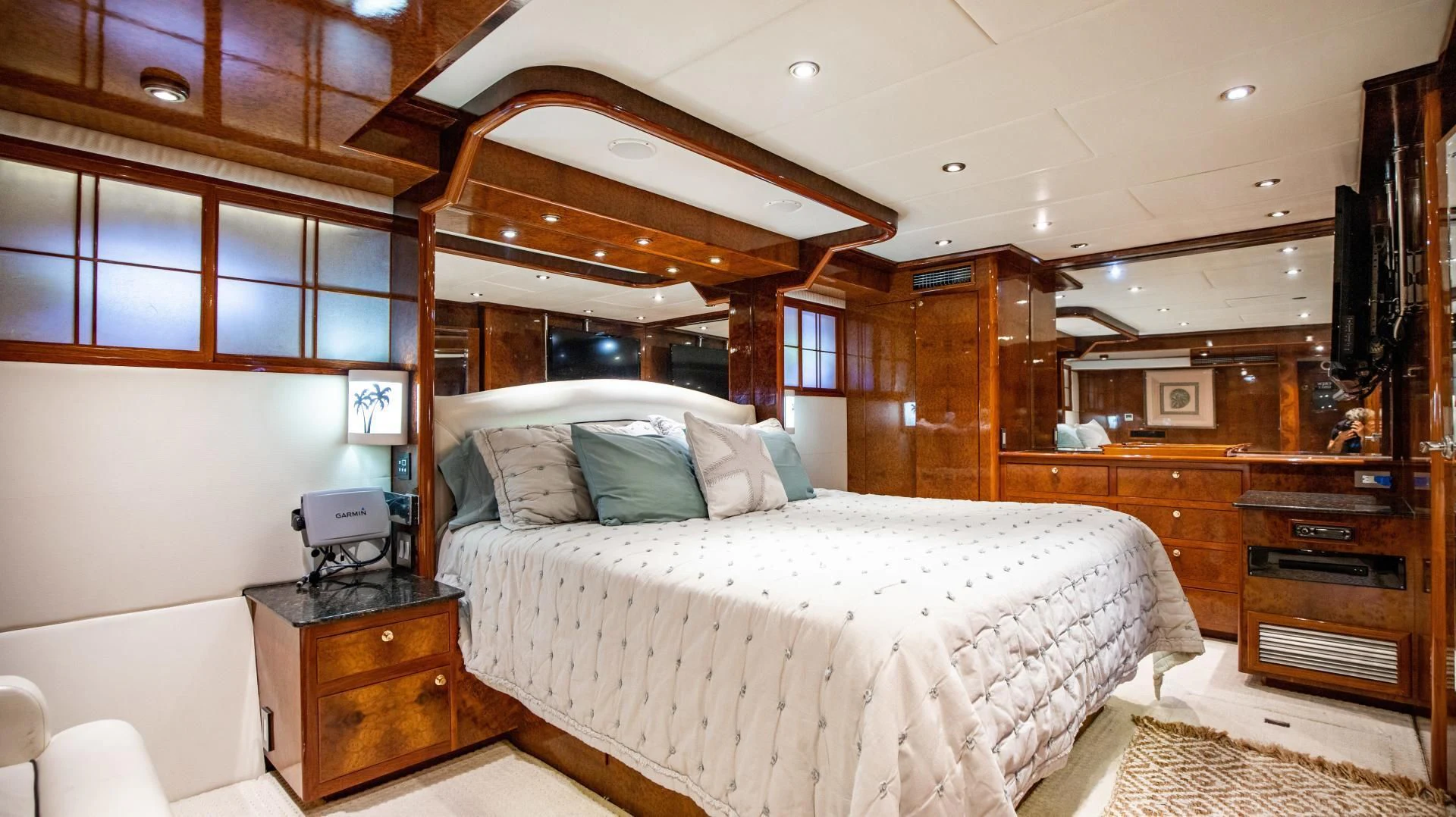 a bedroom with a bed and a dresser aboard DREAMCHASER Yacht for Sale