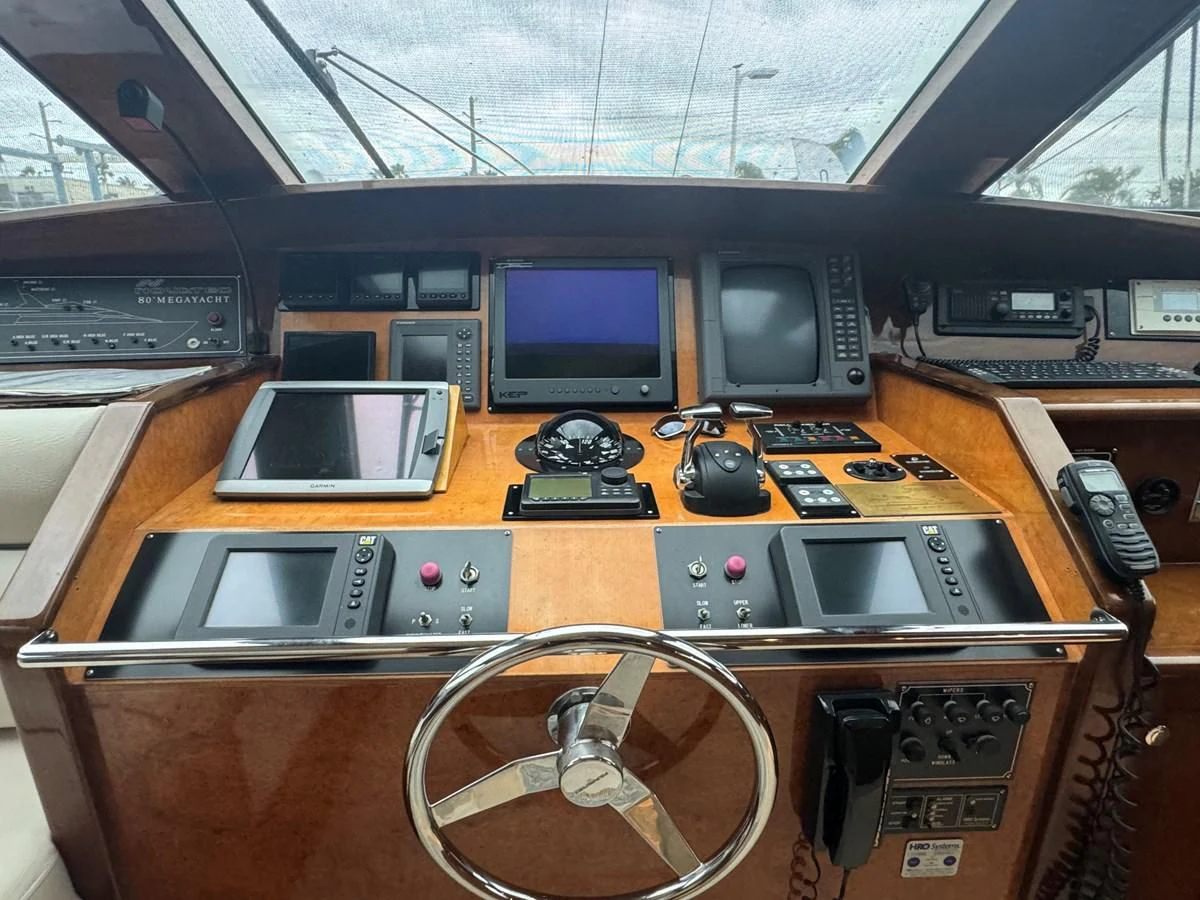 a wooden table with a couple of computers and a couple of monitors aboard DREAMCHASER Yacht for Sale