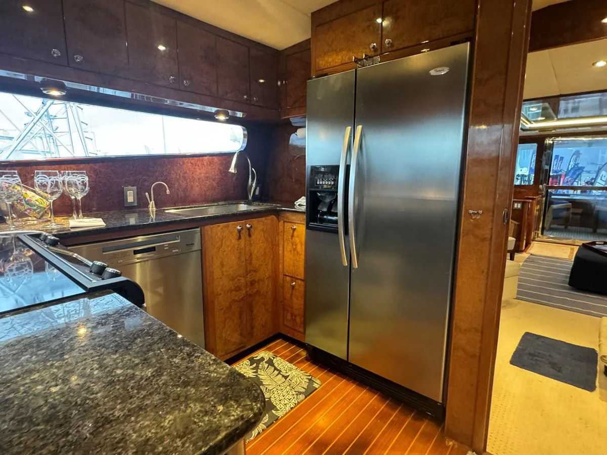 a kitchen with a stainless steel refrigerator aboard DREAMCHASER Yacht for Sale