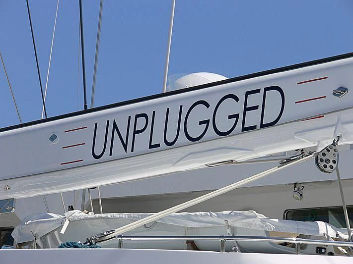 a white boat with a sign on it aboard UNPLUGGED Yacht for Sale