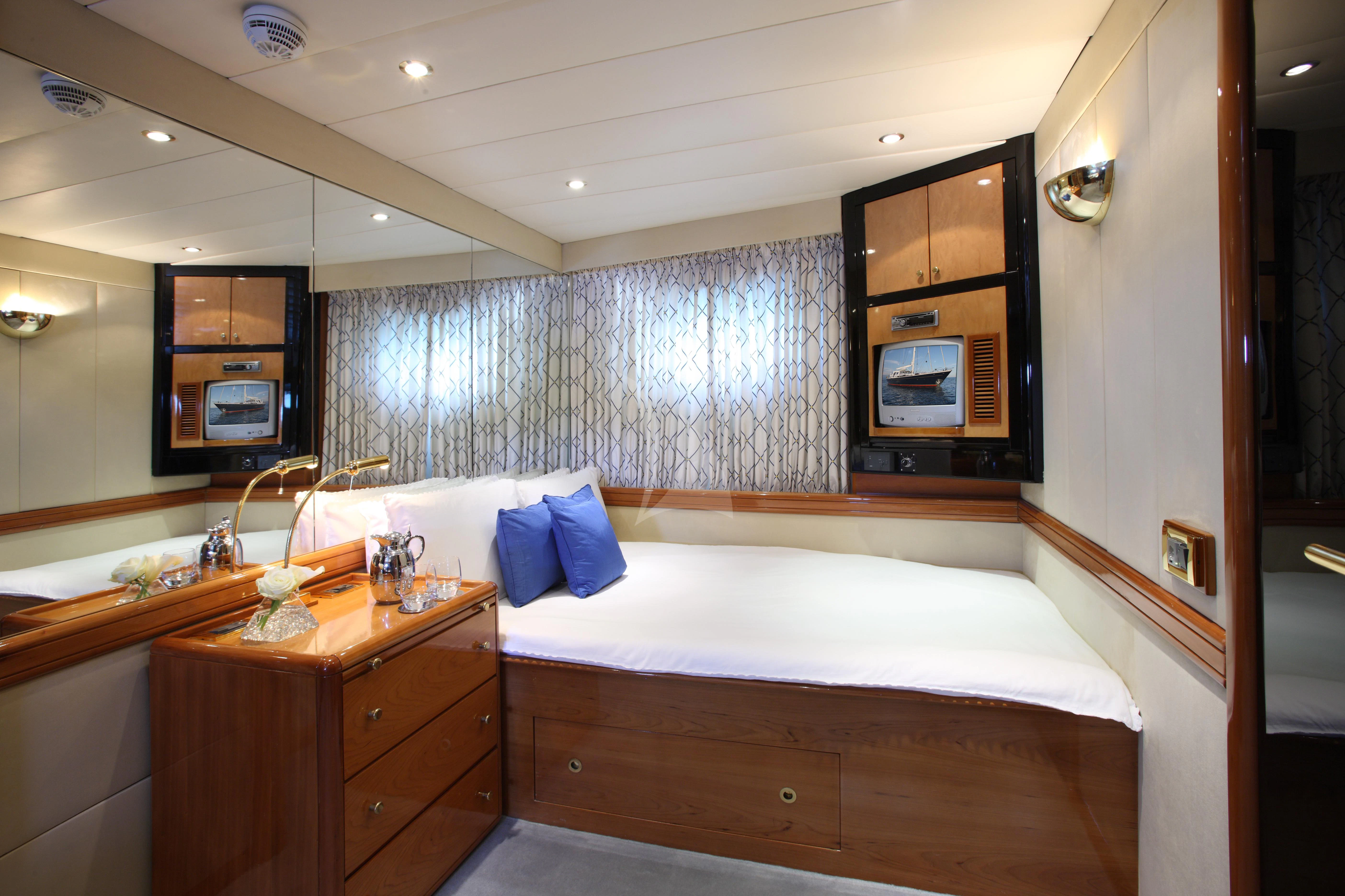 a room with a bed and a television aboard UNPLUGGED Yacht for Sale