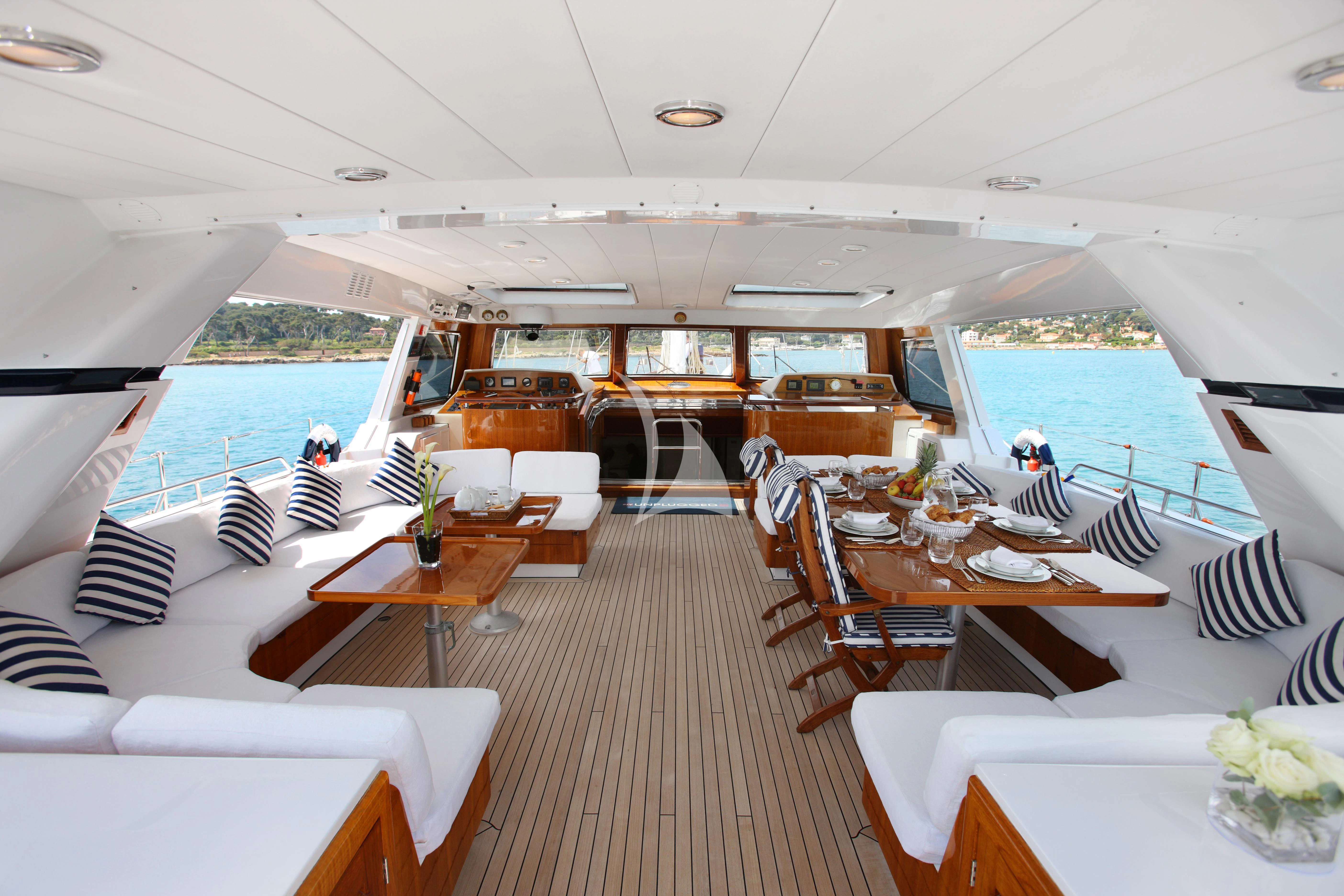 a boat with tables and chairs aboard UNPLUGGED Yacht for Sale