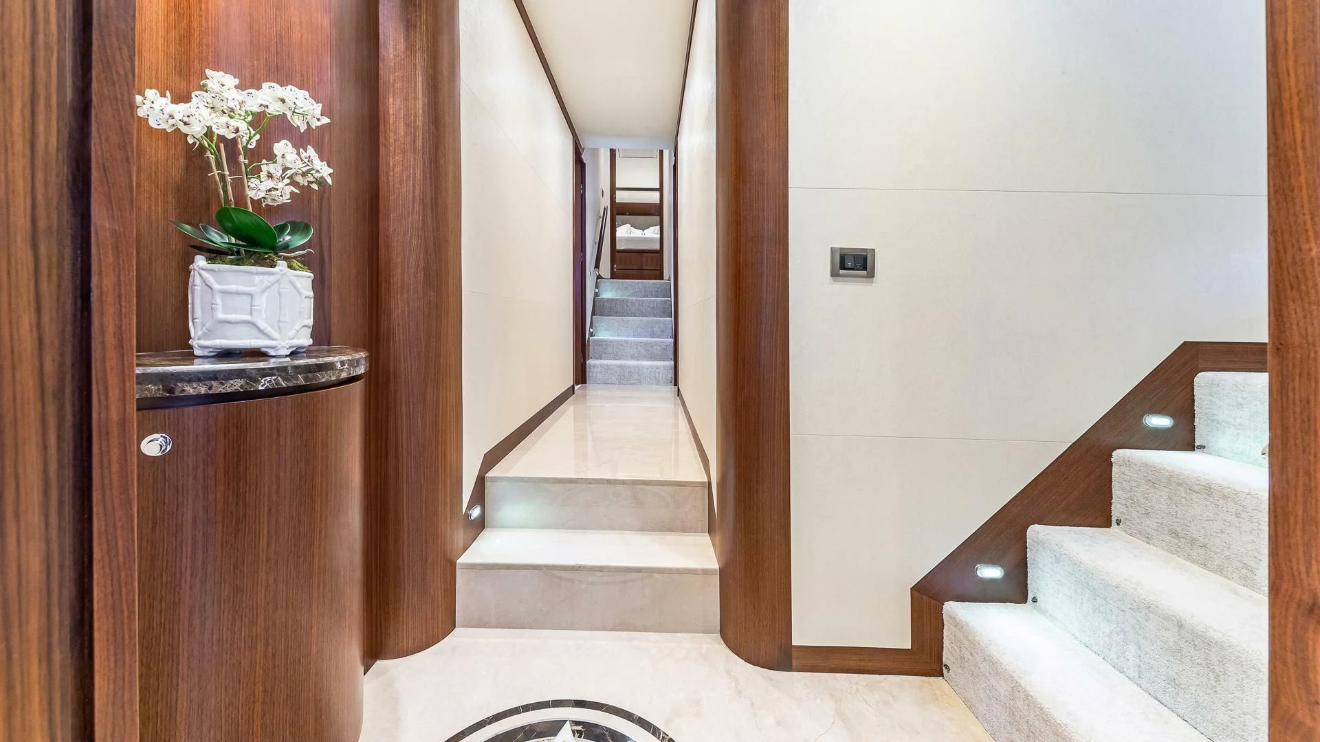 a hallway with a white wall and a white rug aboard BRAVO ZULU II Yacht for Sale