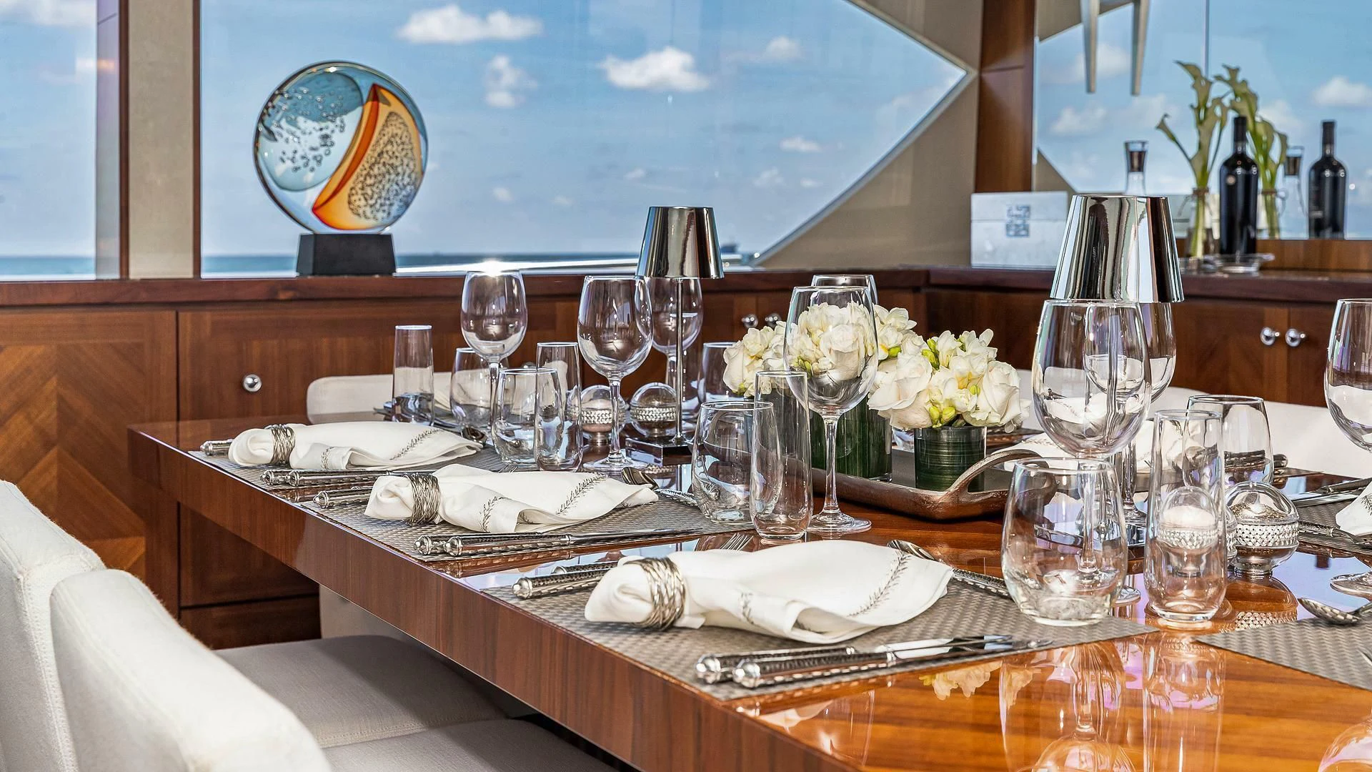 a table with wine glasses and flowers aboard BRAVO ZULU II Yacht for Sale