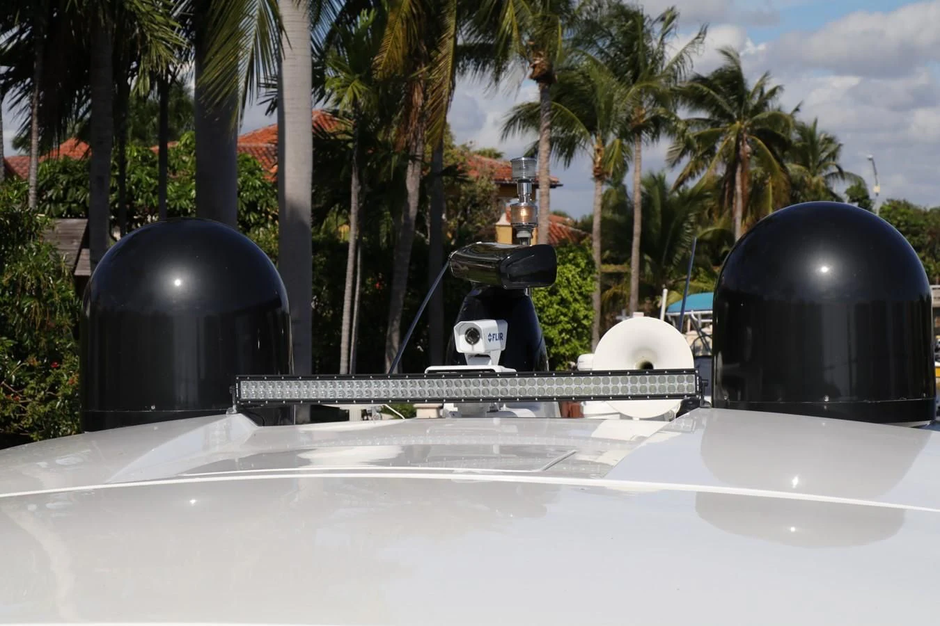 a black and white object on a surface with palm trees and a blue sky aboard VANTAGE Yacht for Charter