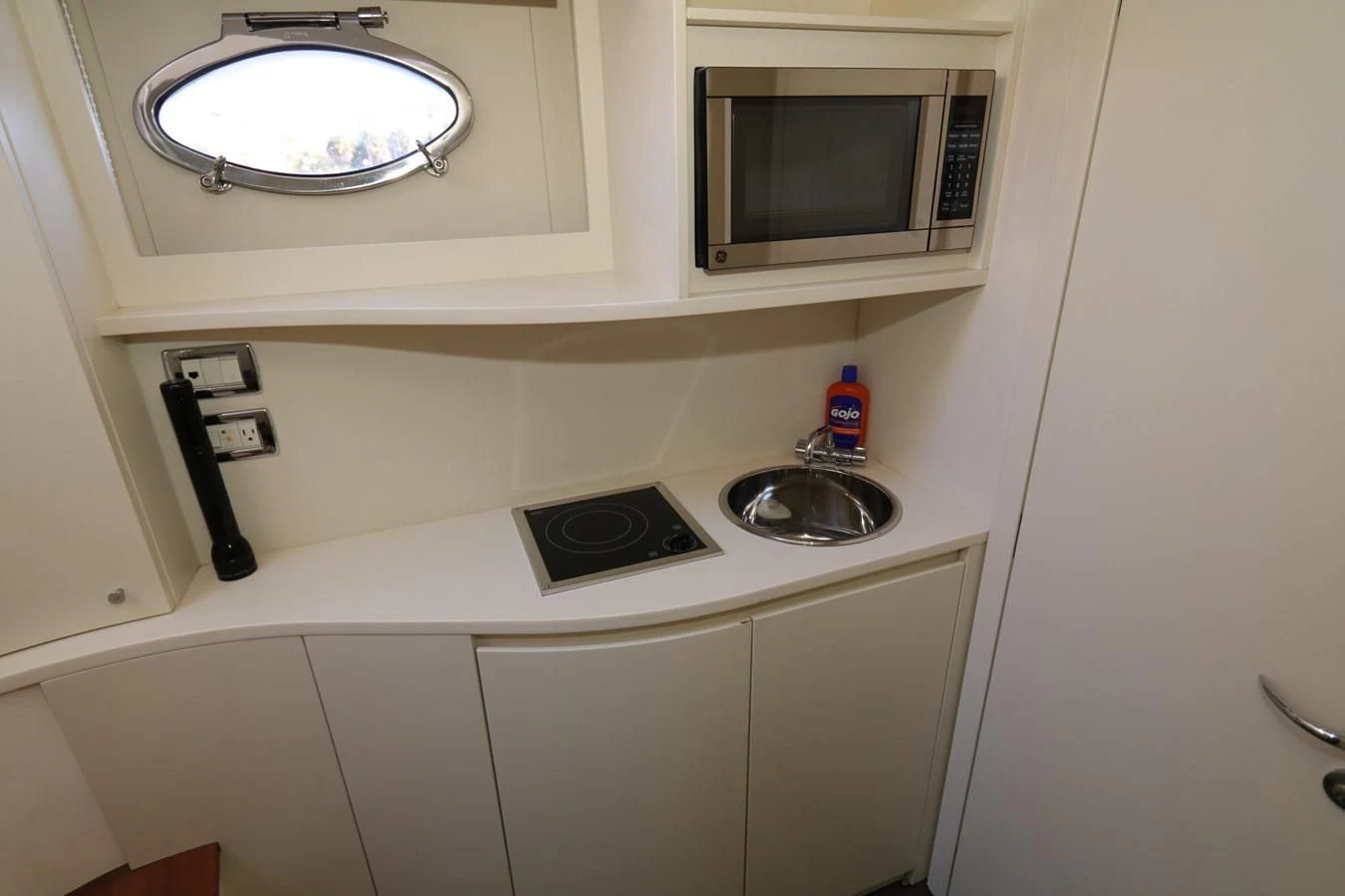 a sink with a microwave above it aboard VANTAGE Yacht for Charter