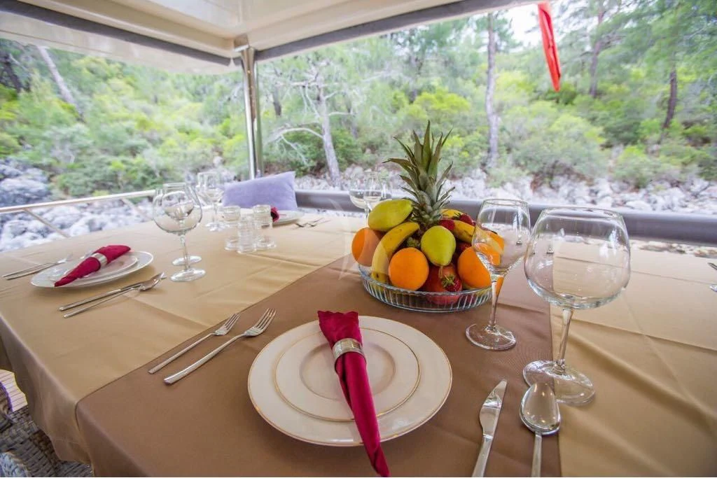 a table with food and glasses on it aboard SIMAY S Yacht for Sale