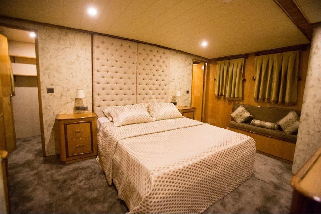 a bedroom with a bed and a dresser aboard SIMAY S Yacht for Sale