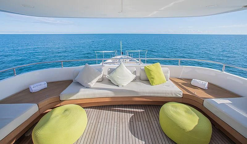 a wooden table with a white umbrella on it next to a yellow lemon aboard RUSCELLO Yacht for Sale