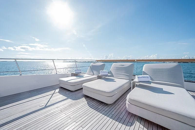 a deck with white lounge chairs on it and a body of water in the background aboard RUSCELLO Yacht for Sale