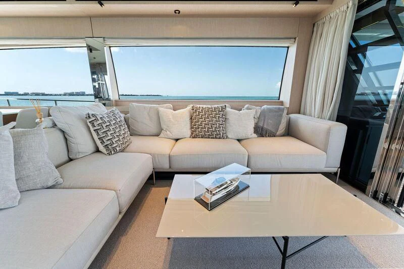 a couch with pillows and a coffee table in front of a window aboard FERRETTI 780/41 Yacht for Sale