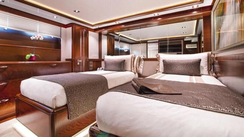 a room with beds and a chair aboard VIVIERAE II Yacht for Sale