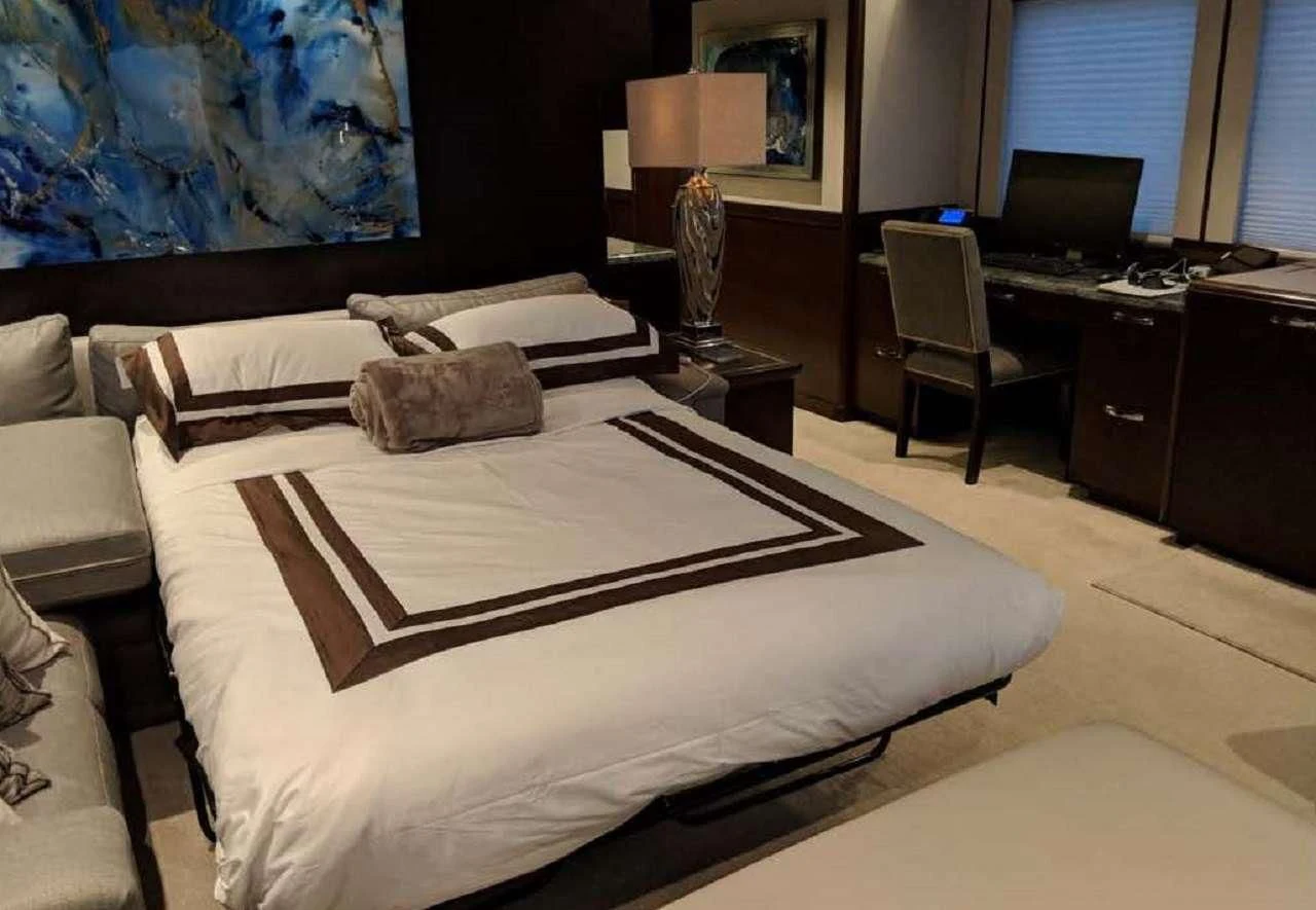 a bedroom with a bed and a desk aboard VIVIERAE II Yacht for Sale