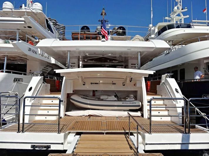 a person standing on a deck looking at a large ship aboard LEGACY Yacht for Sale