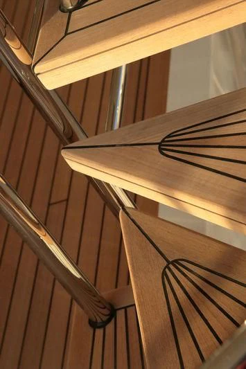 a wooden staircase with metal railings aboard VICA Yacht for Sale
