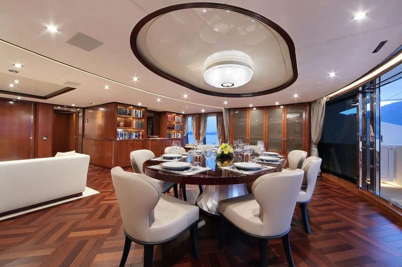 a large dining room with white chairs aboard VICA Yacht for Sale