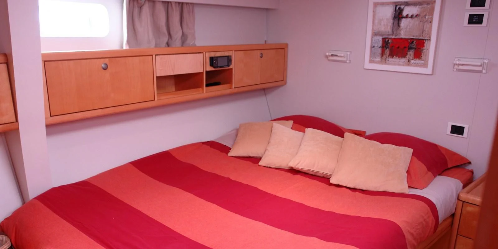 a bed with red sheets aboard DJANGO TOO Yacht for Charter