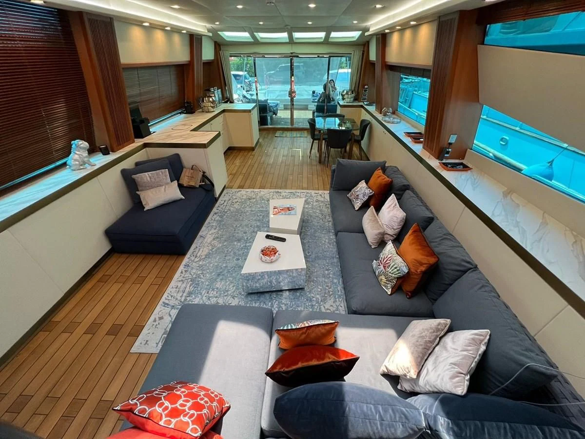 a living room with a large blue couch and a large window aboard EYE Yacht for Sale