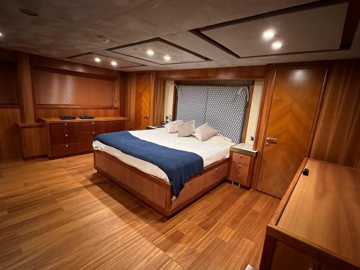 a bedroom with a bed and a desk aboard EYE Yacht for Sale