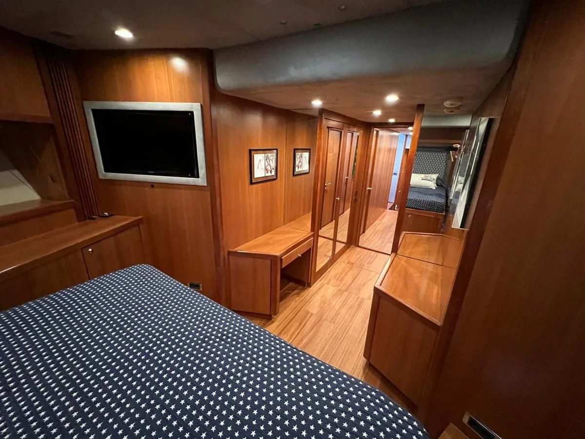 a bedroom with a bed and a television aboard EYE Yacht for Sale