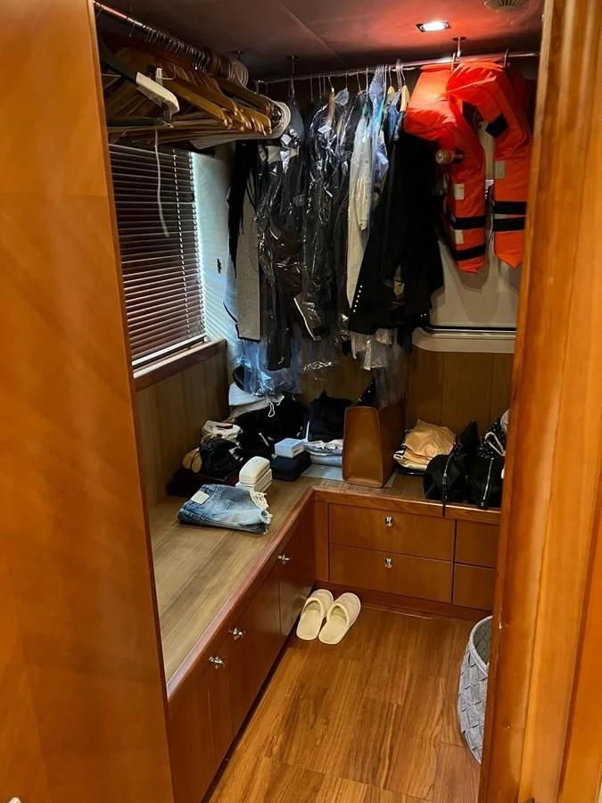 a closet with clothes on the wall aboard EYE Yacht for Sale