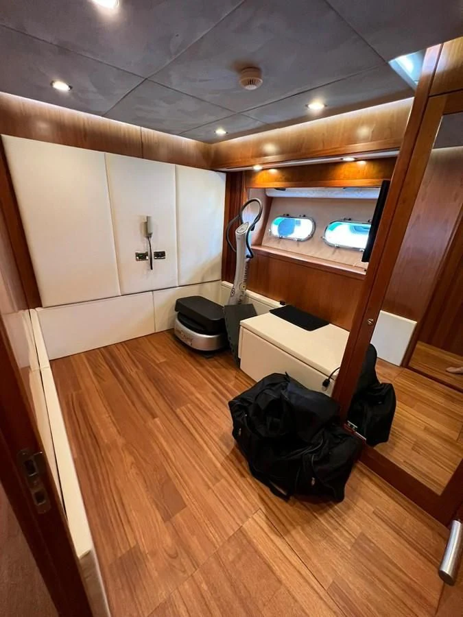 a room with a wood floor and a mirror on the wall aboard EYE Yacht for Sale