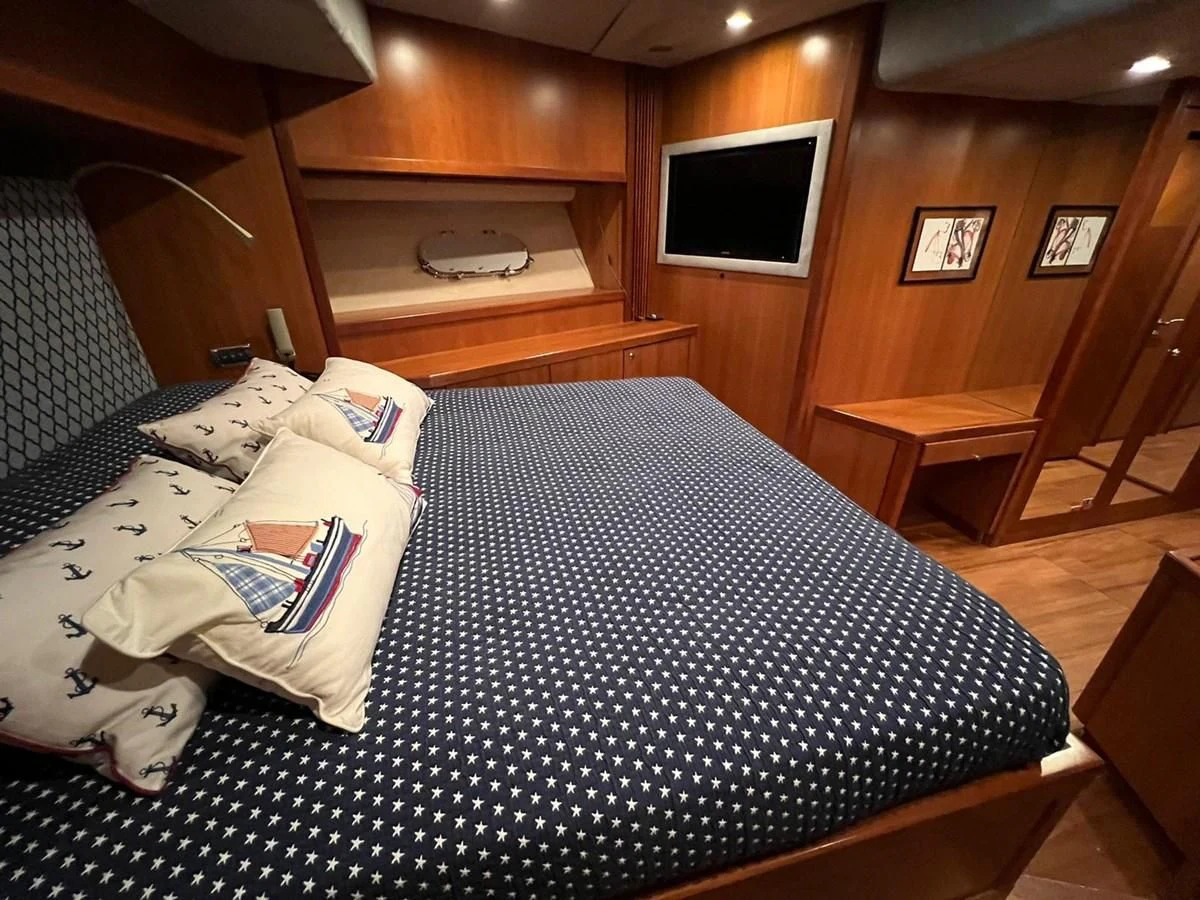 a bed with a blue comforter aboard EYE Yacht for Sale