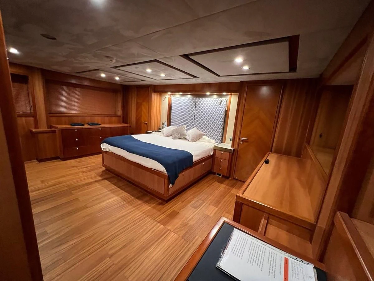 a bedroom with a bed and a wood wall aboard EYE Yacht for Sale