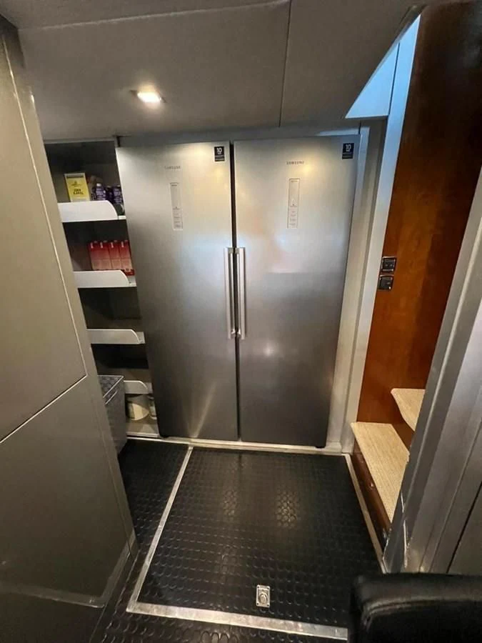 a room with a fridge and a door aboard EYE Yacht for Sale