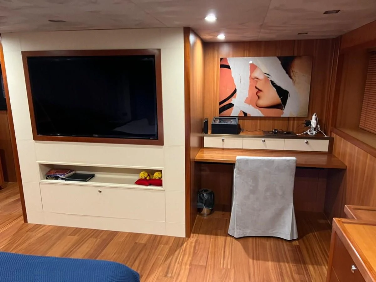 a room with a tv and a dresser aboard EYE Yacht for Sale