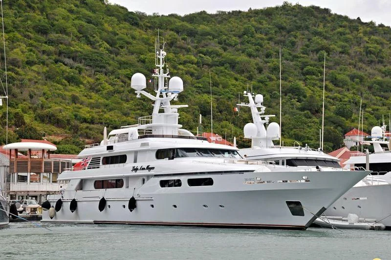 a large white boat in a harbor aboard LADY ANN MAGEE Yacht for Sale