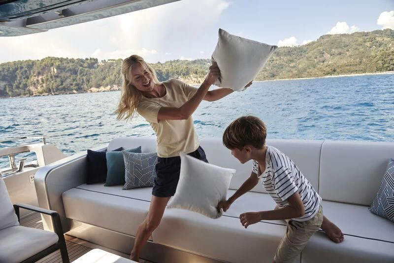 a person and a boy holding hands and sitting on a couch aboard GIO4 Yacht for Sale