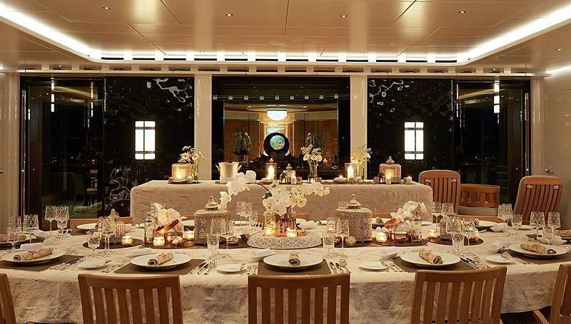a large table set with plates and glasses aboard BARBARA Yacht for Charter