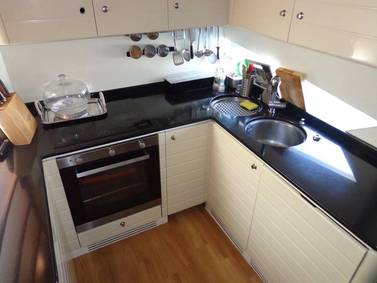 a kitchen with black appliances aboard FERRETTI 760 Yacht for Sale