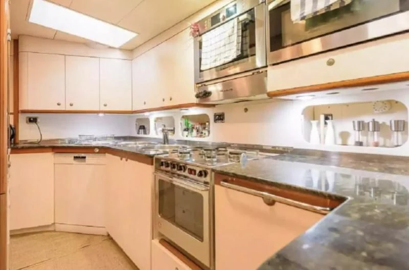 a kitchen with white cabinets aboard ZANZIBAR Yacht for Sale