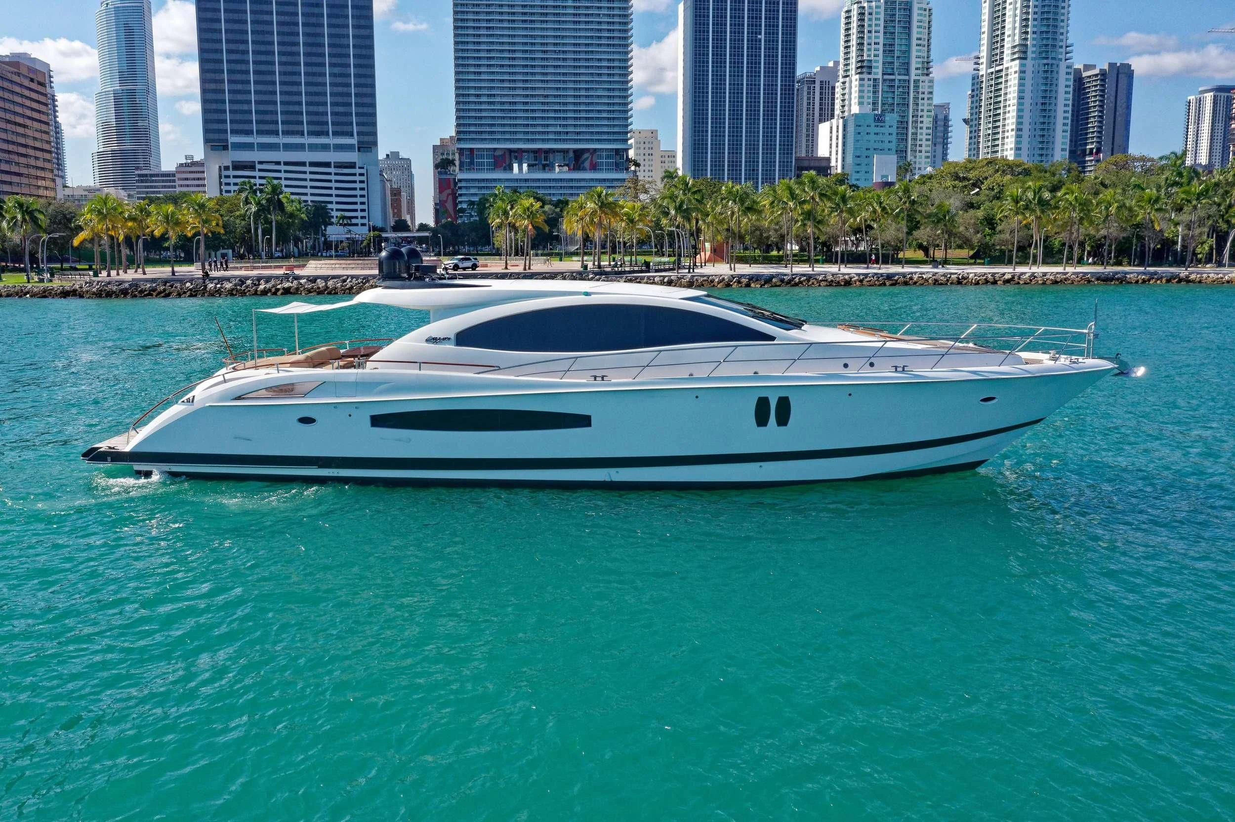 a white boat in a body of water with buildings in the background aboard XCELL Yacht for Sale