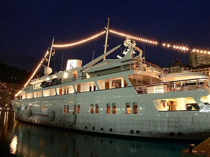 a large white boat with lights on it at night aboard LADY K II Yacht for Sale
