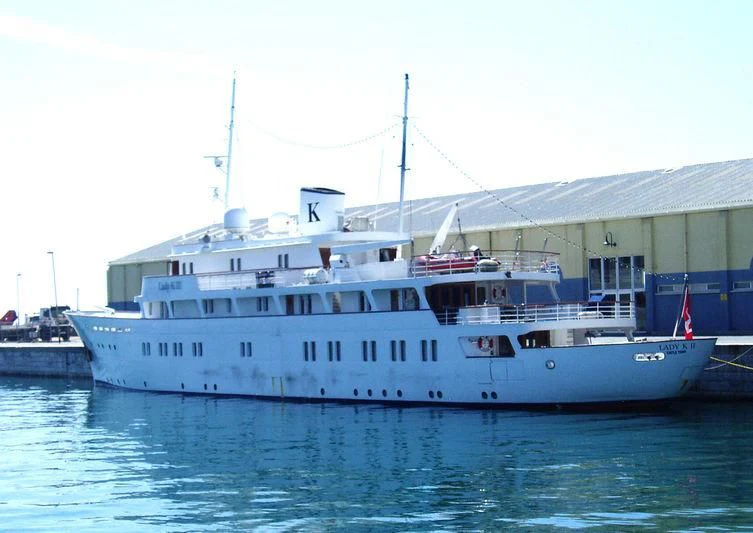 a large white boat in a harbor aboard LADY K II Yacht for Sale