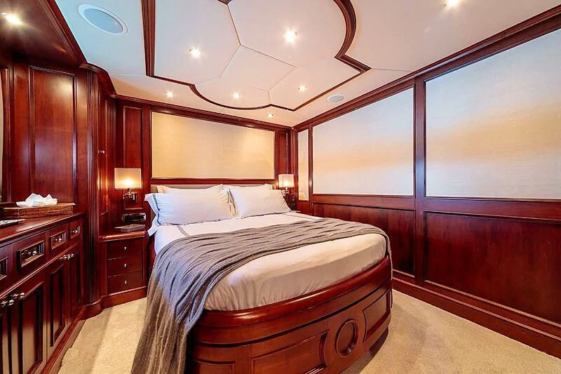 a bedroom with a bed and a desk aboard BANG! Yacht for Charter