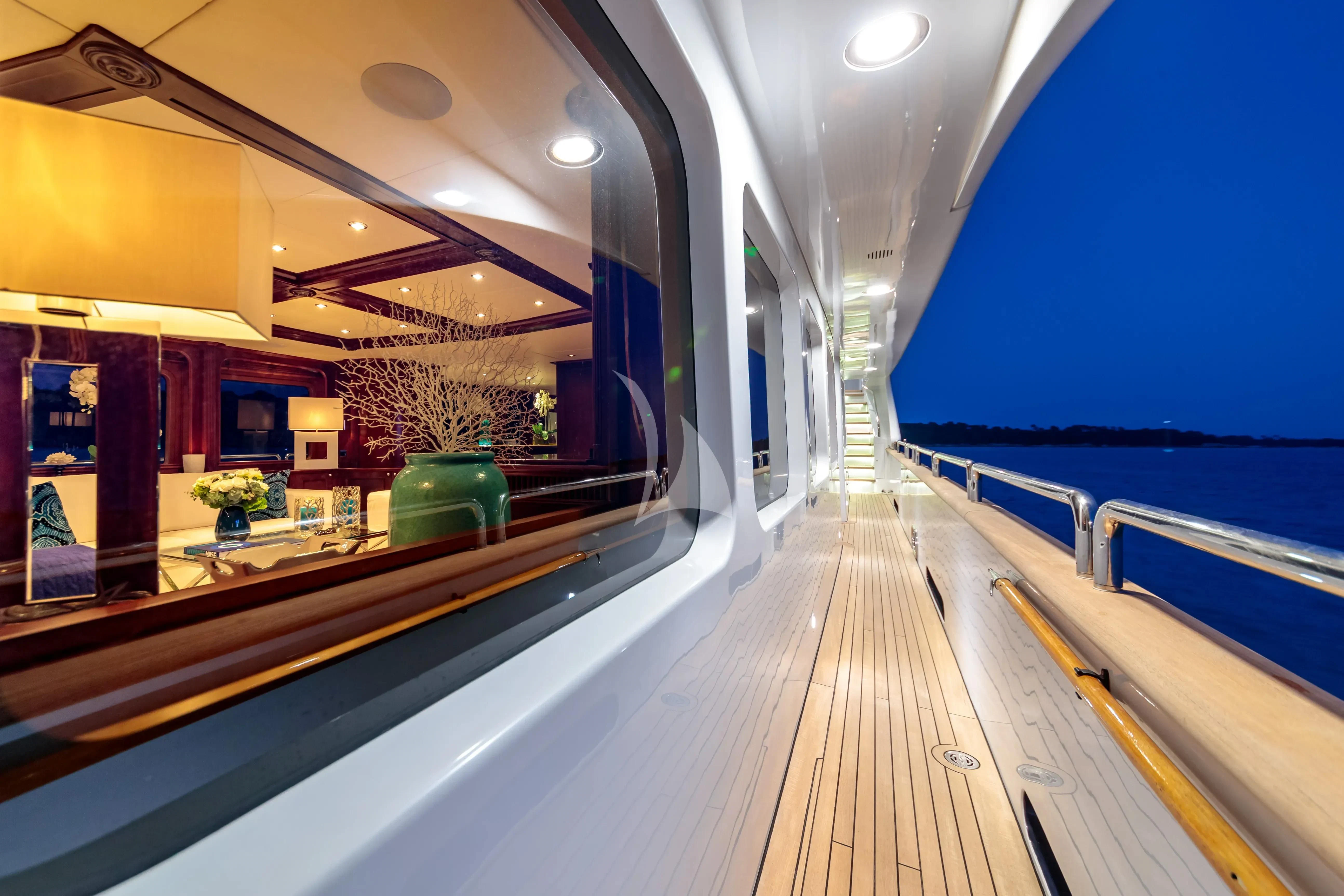 a long wooden walkway with a railing and a railing and a body of water with a building and aboard BANG! Yacht for Charter