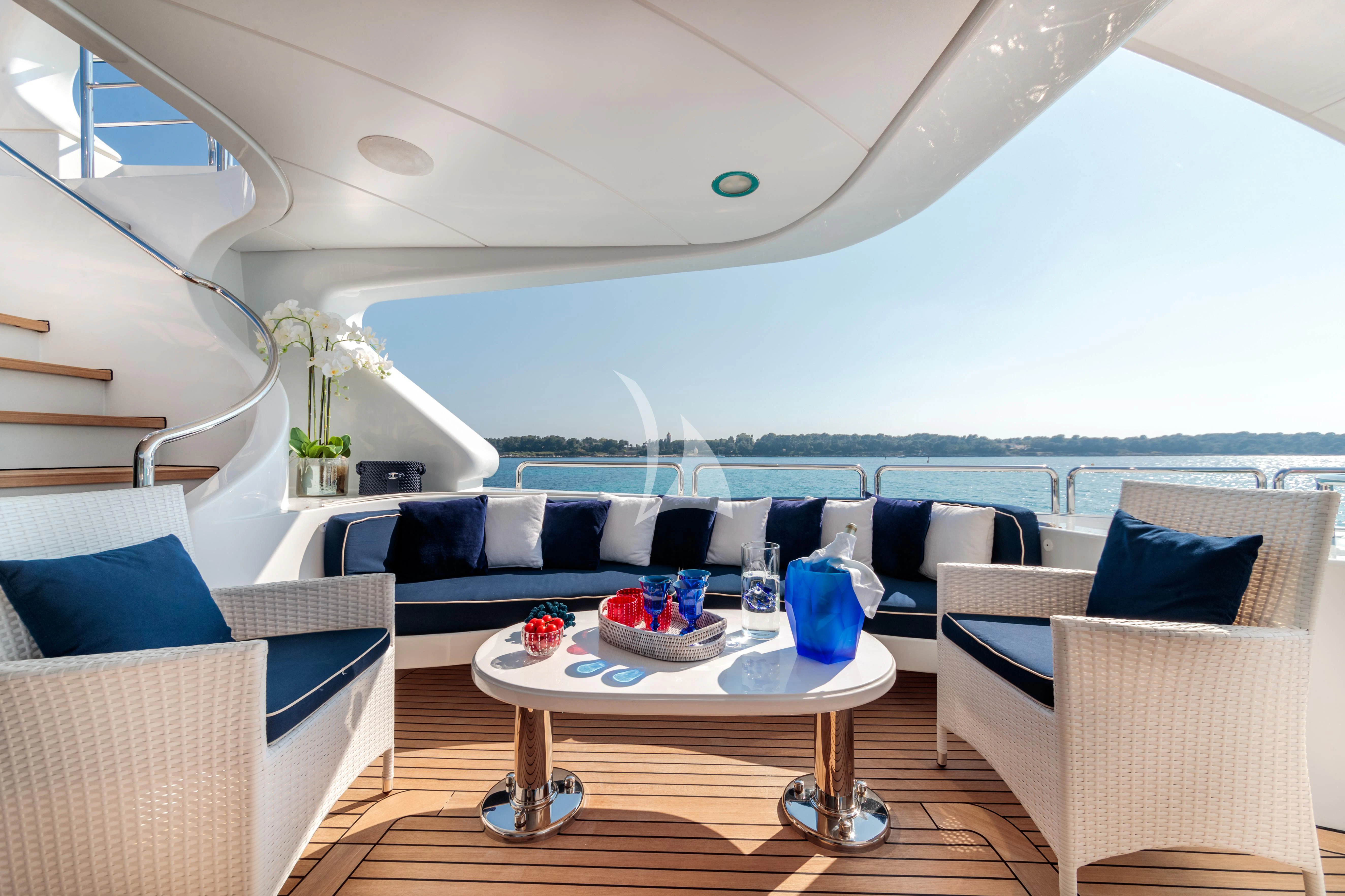 a living room with a large white sofa and a table with chairs aboard BANG! Yacht for Charter