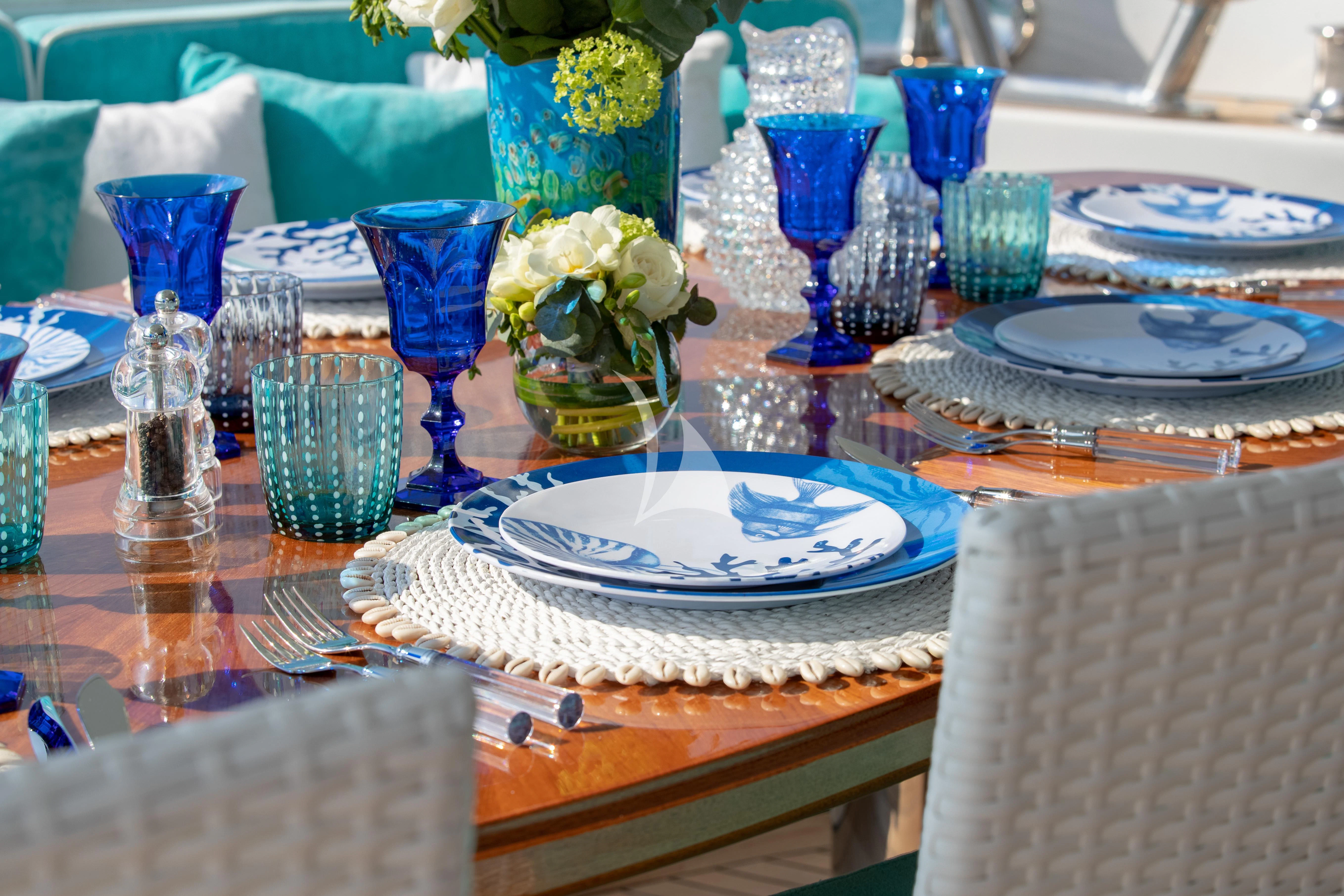 a table with plates and vases on it aboard BANG! Yacht for Charter