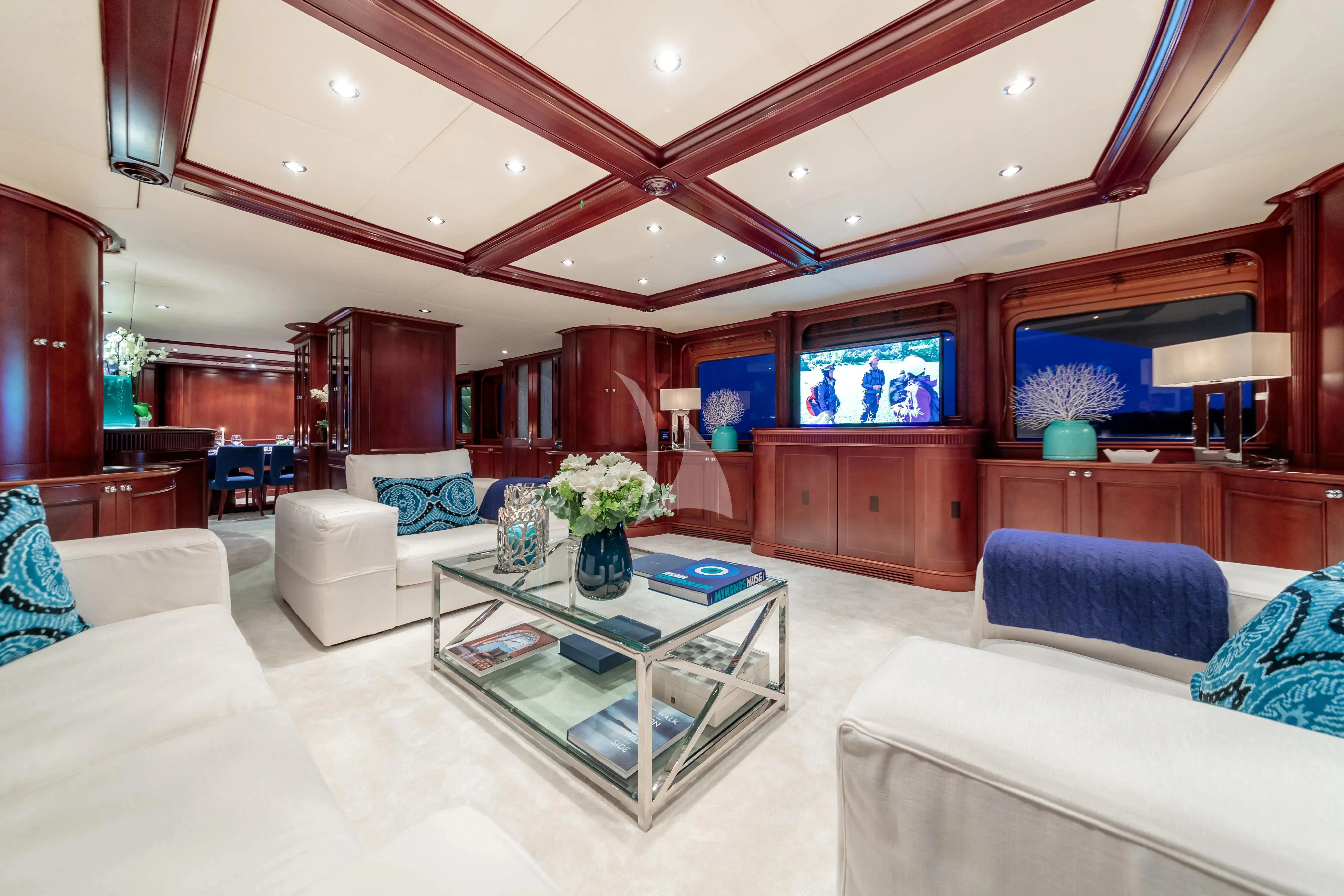 a living room with a table and couches aboard BANG! Yacht for Charter
