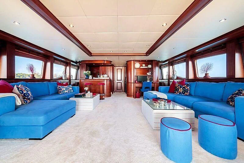 a living room with blue couches aboard BANG! Yacht for Charter